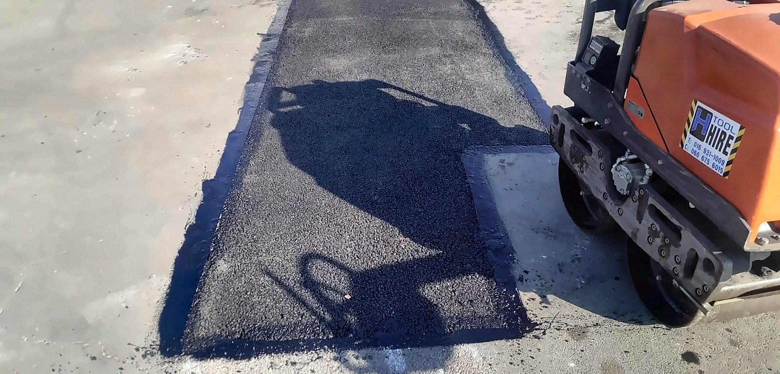 Asphalt patch compacted with roller