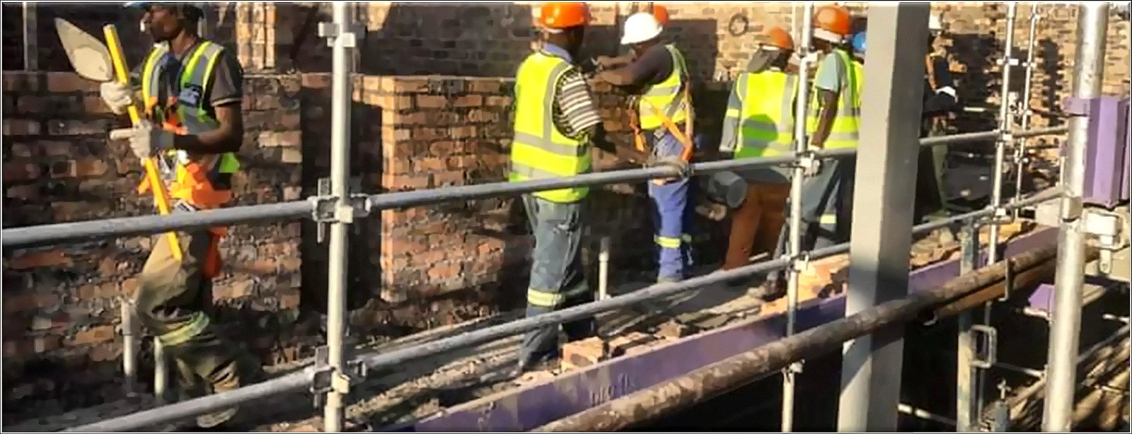 TLM crew in hi-vis on scaffolding during brickwork